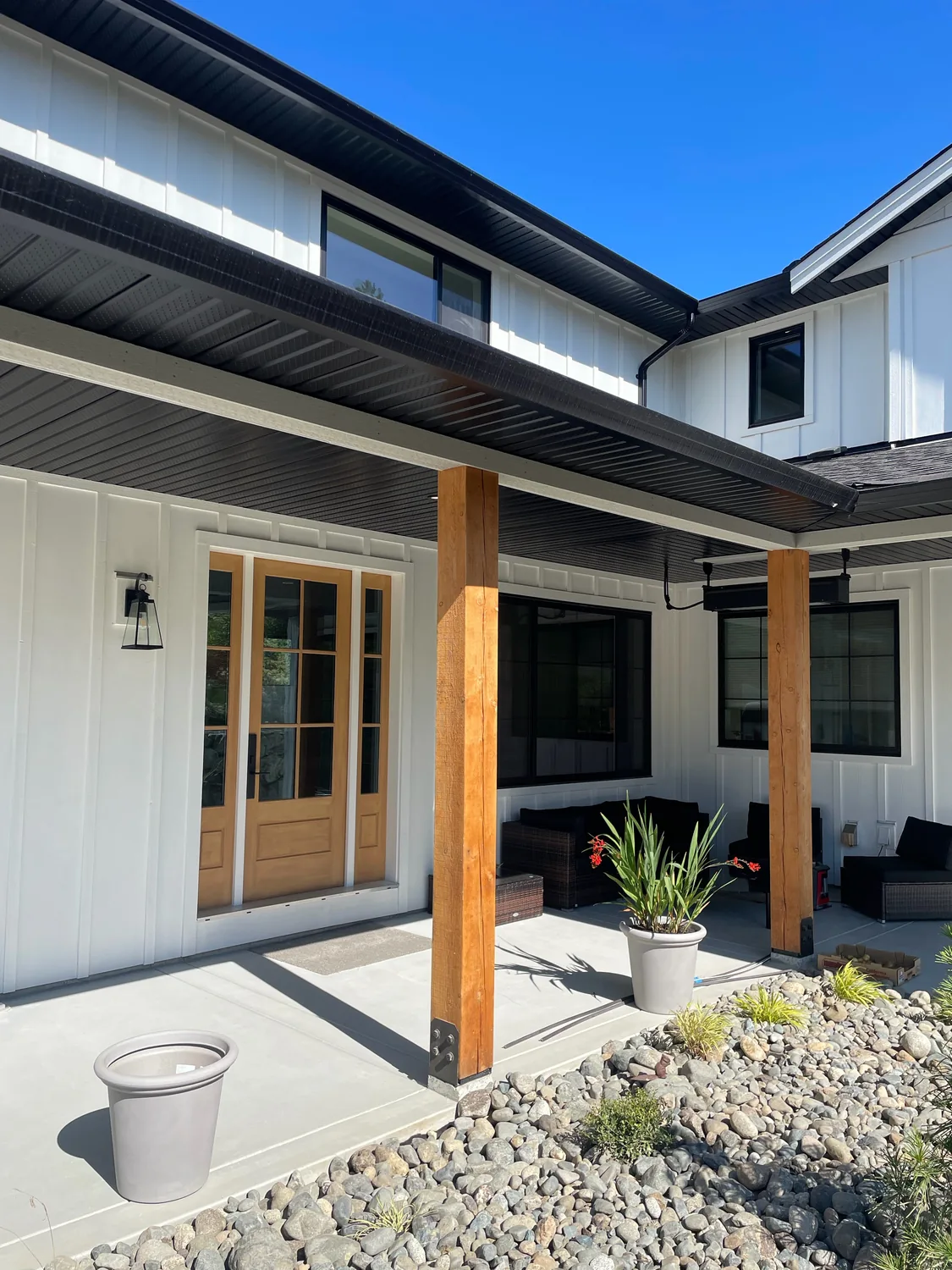 White painted home entry with warm timber posts and dark trim