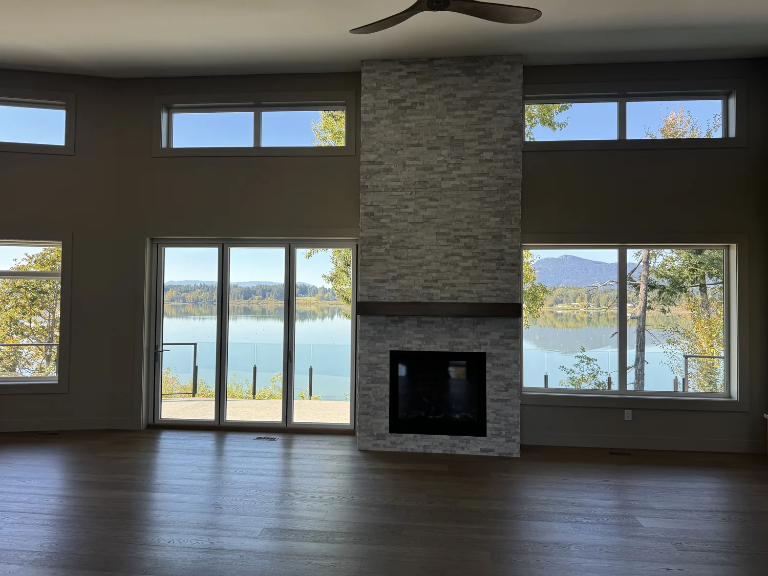 Spacious living room with painted walls, fireplace and water view