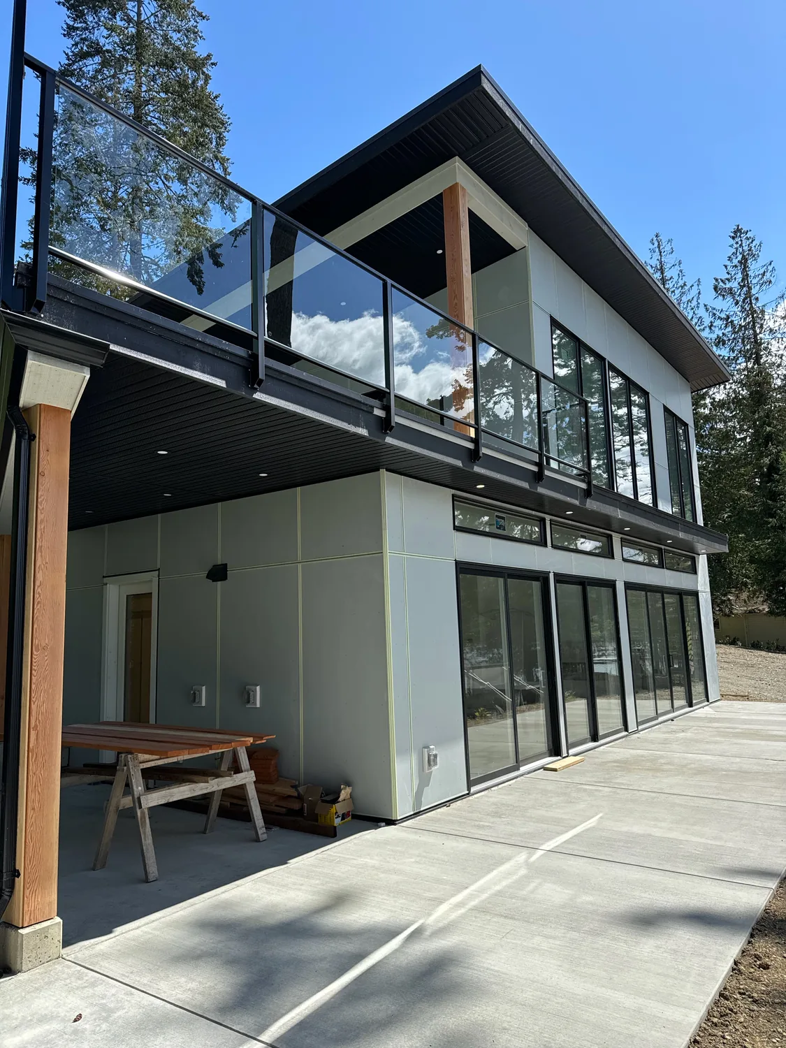 Modern two-story exterior with light painted siding and dark window frames